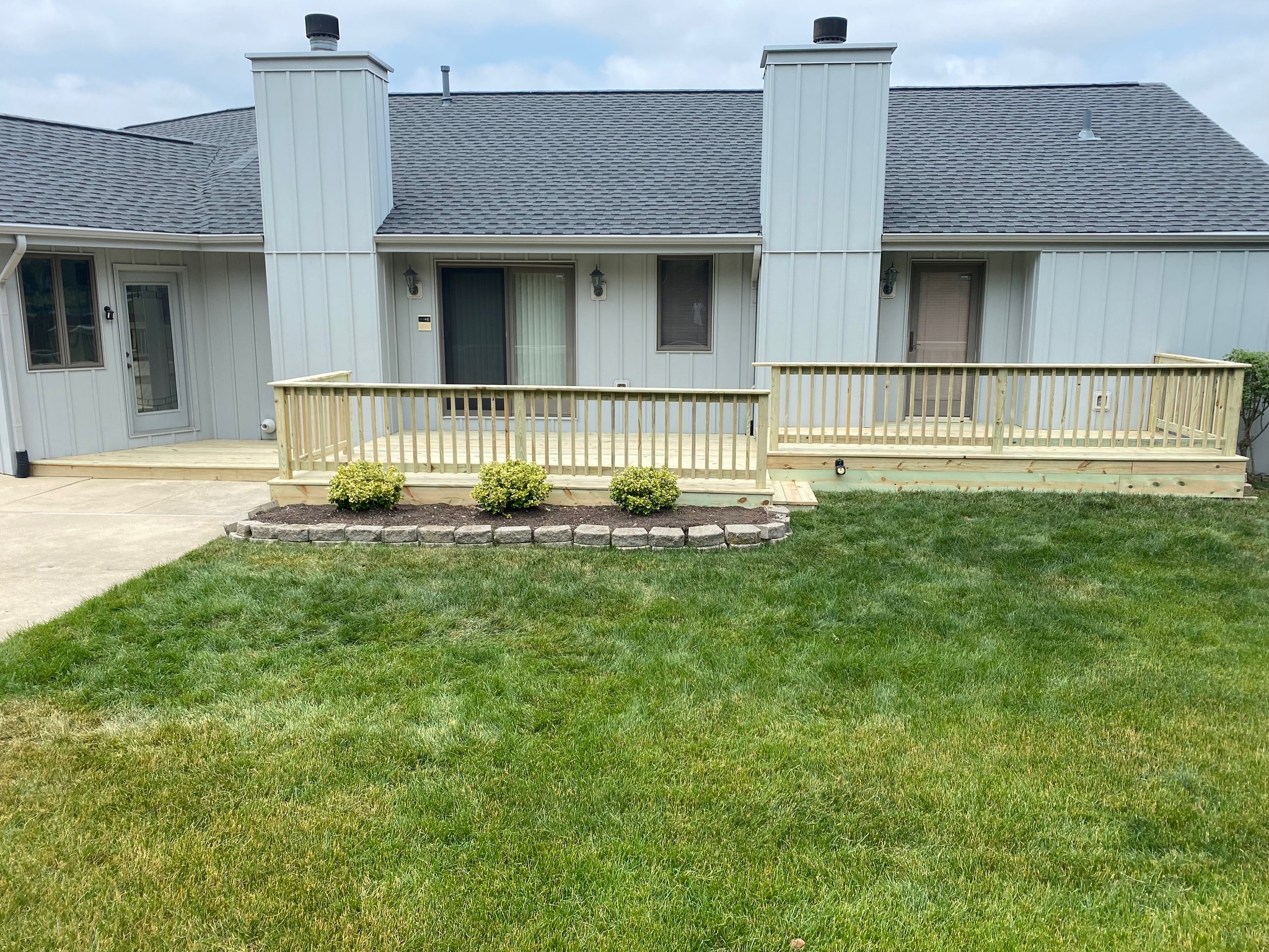 Multi-level custom pressure-treated wood deck and secure safety handrails installed by Precision Exterior Inc. for a residential home in Lena, IL.