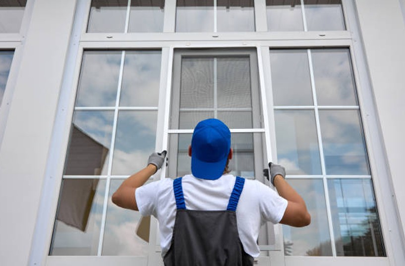 A professional contractor from Precision Exterior Inc. installing a screen on a window.