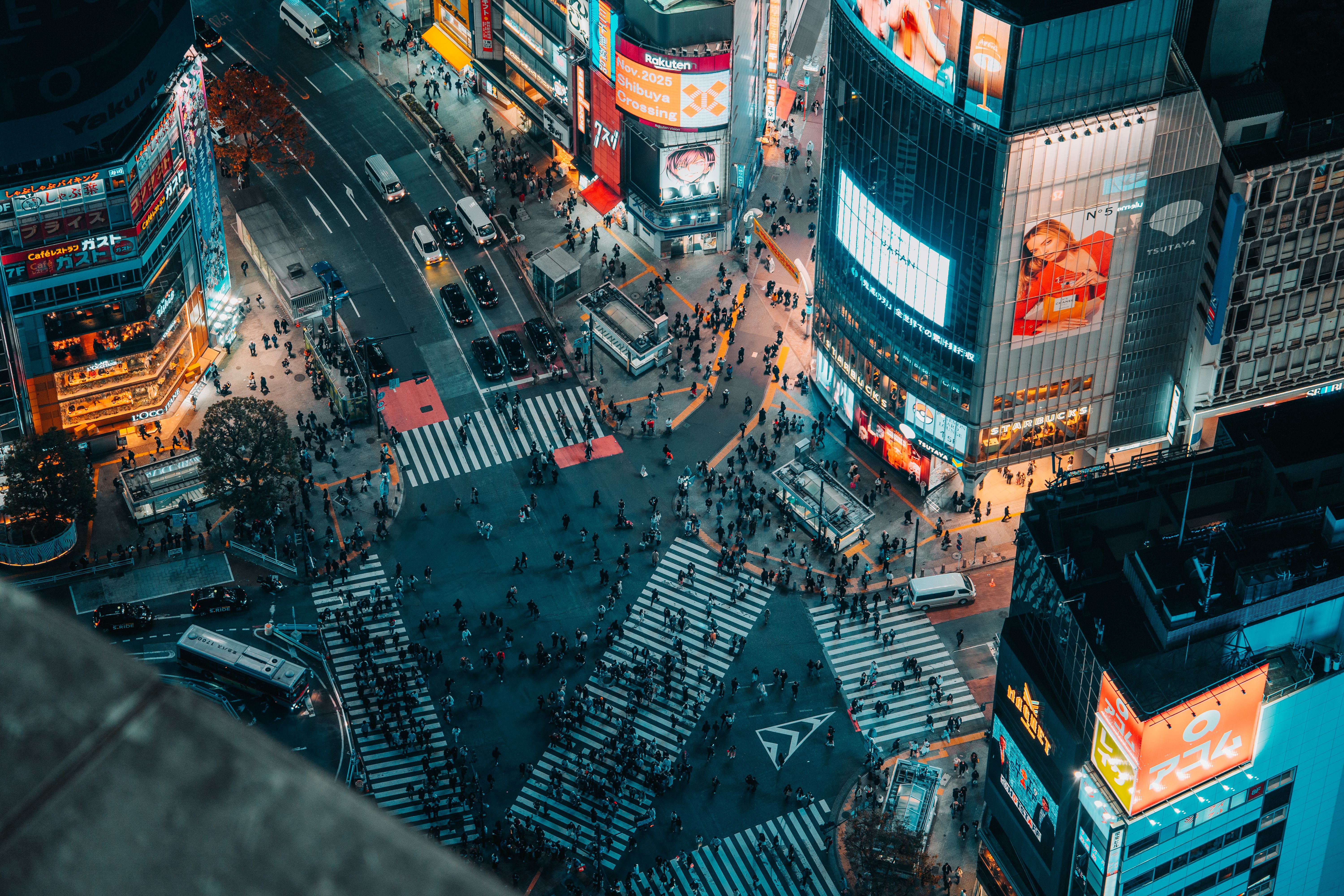 Cruce de Shibuya en Tokio de noche, con gente cruzando y pantallas iluminadas