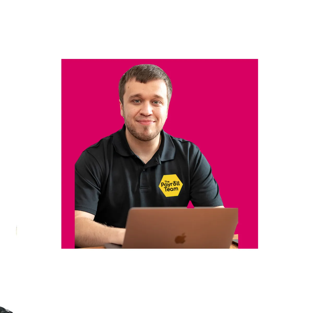 Man using laptop wearing black polo shirt, smiling at the camera 