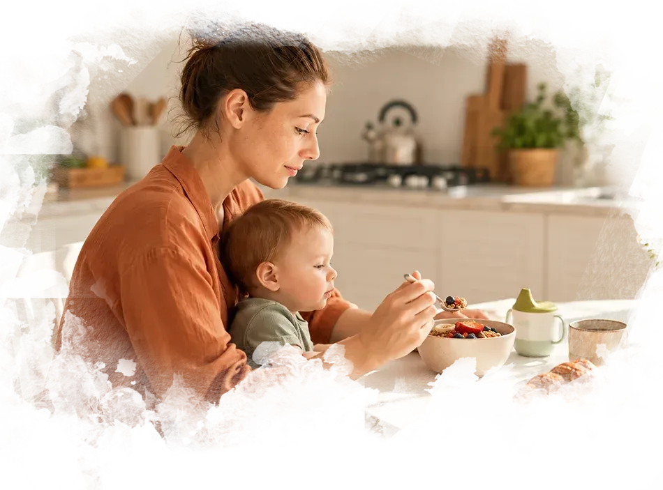 Madre comiendo con su bebé en brazos durante la lactancia materna.