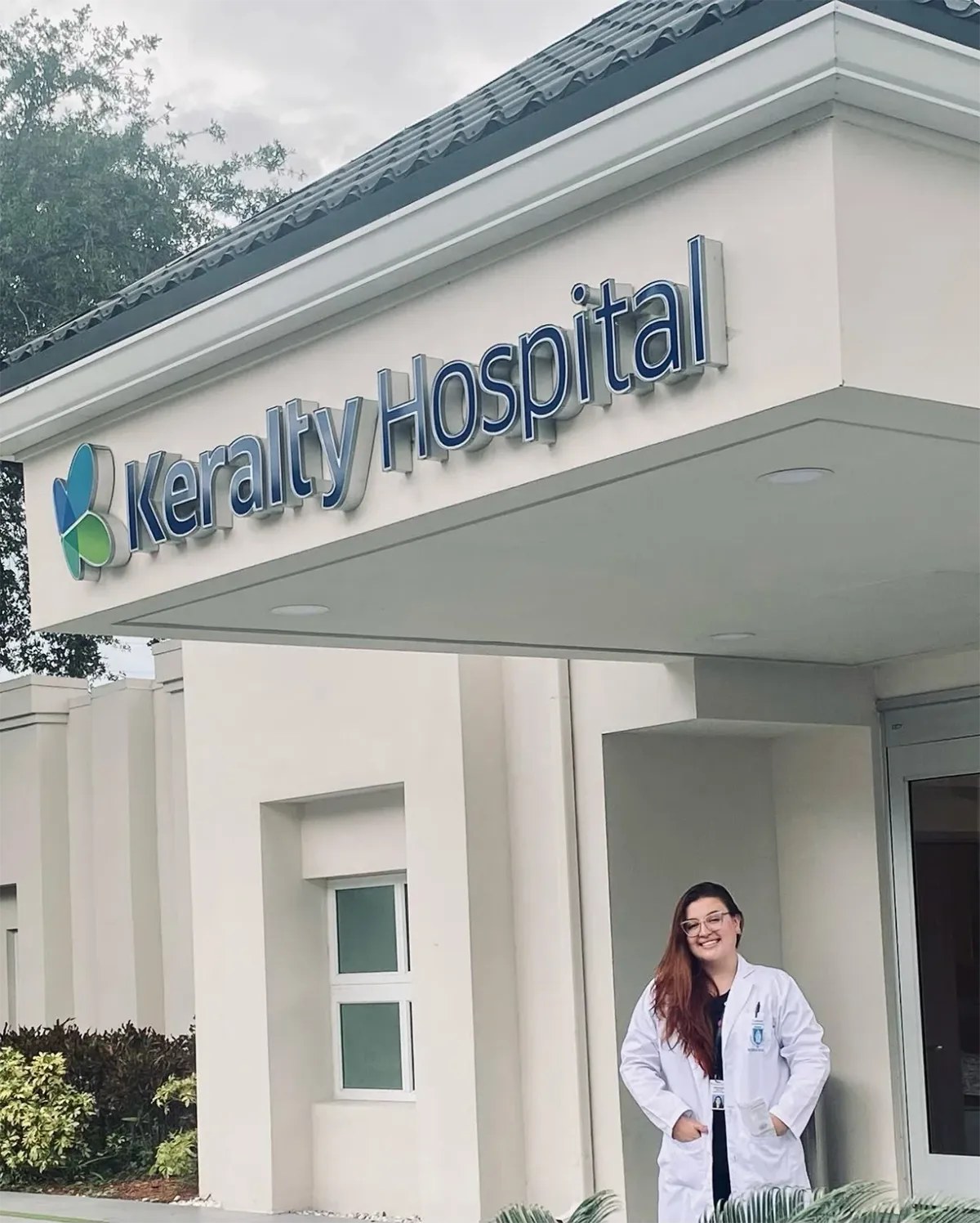 Dra. Verónica Villa con bata médica frente al Keralty Hospital en Miami.