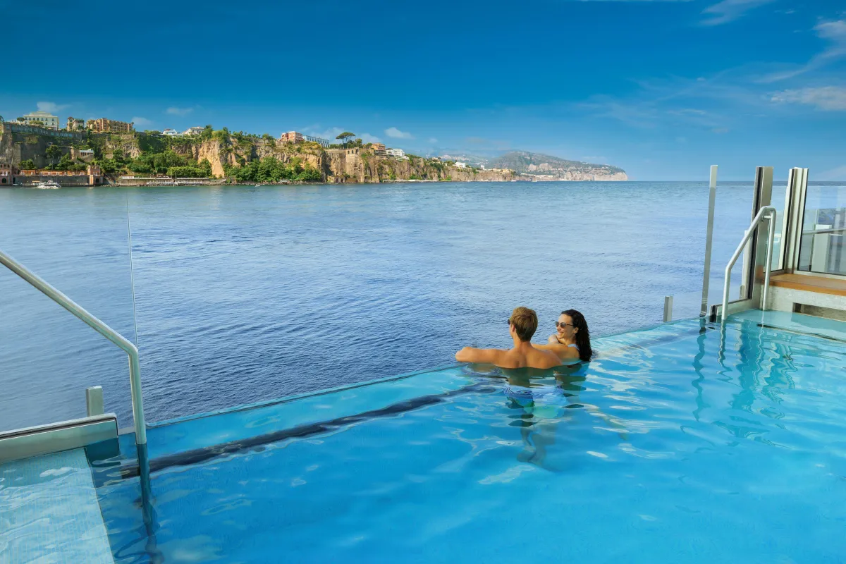 a person wearing a hat standing in front of a mountain