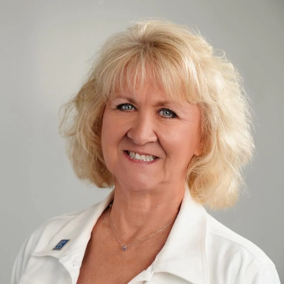 Portrait of an experienced agent in 50s with friendly face, outdoor suburban background.