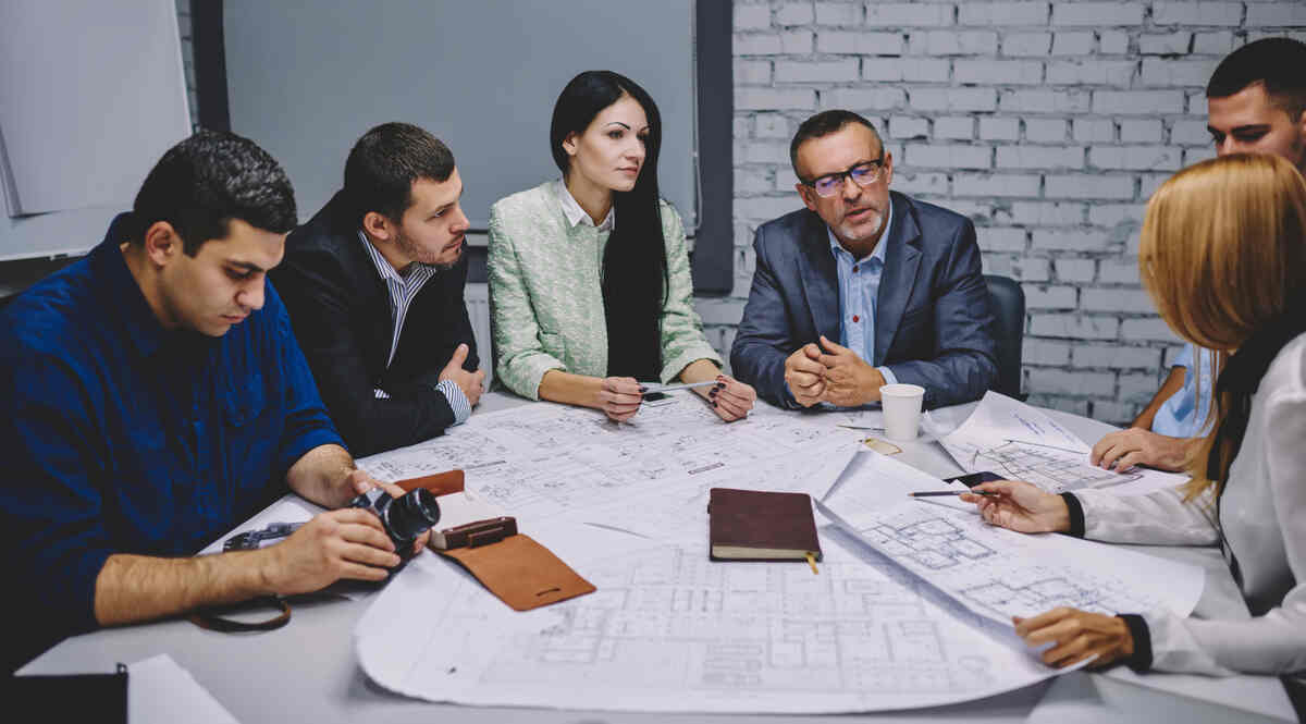 Team reviewing multifamily property investment materials in a conference room