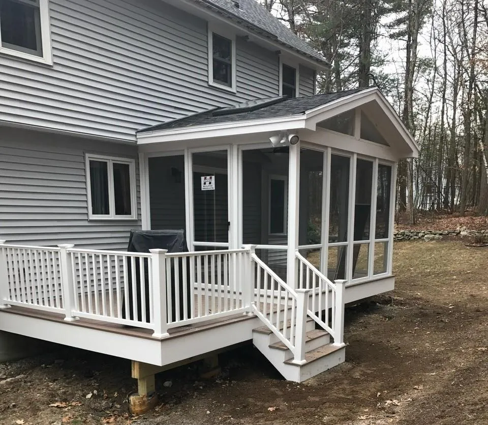 Screened porch with composite deck and white railings installed by McCarthy Exteriors LLC at a residential home in New Hampshire