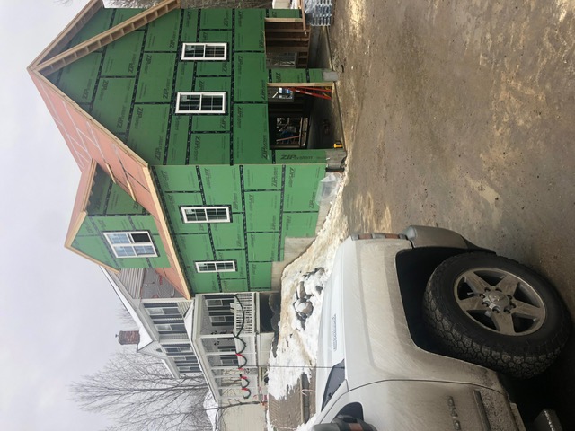 Screened porch with composite deck and white railings installed by McCarthy Exteriors LLC at a residential home in New Hampshire