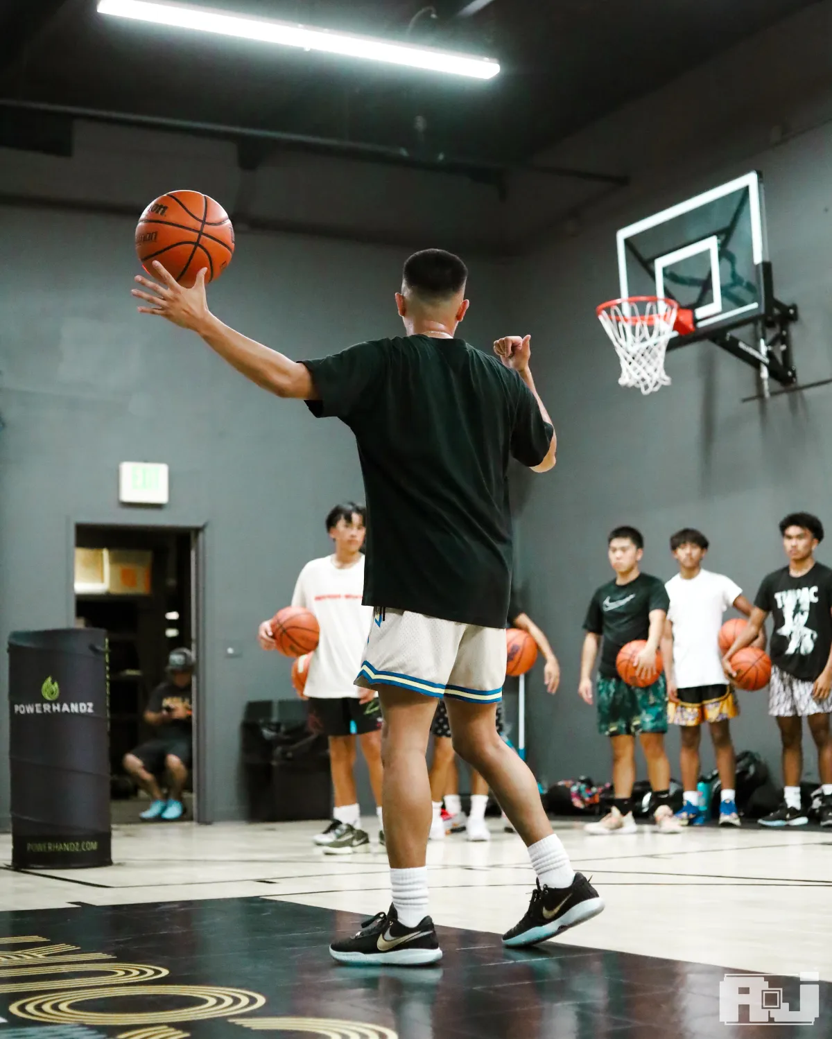 Large group of young basketball players participating in a high-energy skills clinic, led by expert trainer at a By Any Means San Jose session, focusing on player development, teamwork, and advanced techniques.