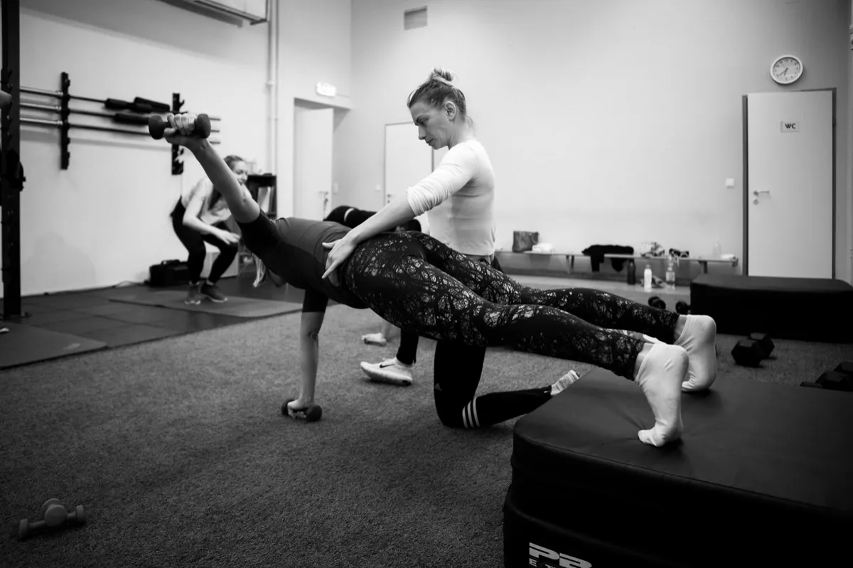 Coach erklärt Mitglied vor dem Training die saubere Bewegungsausführung