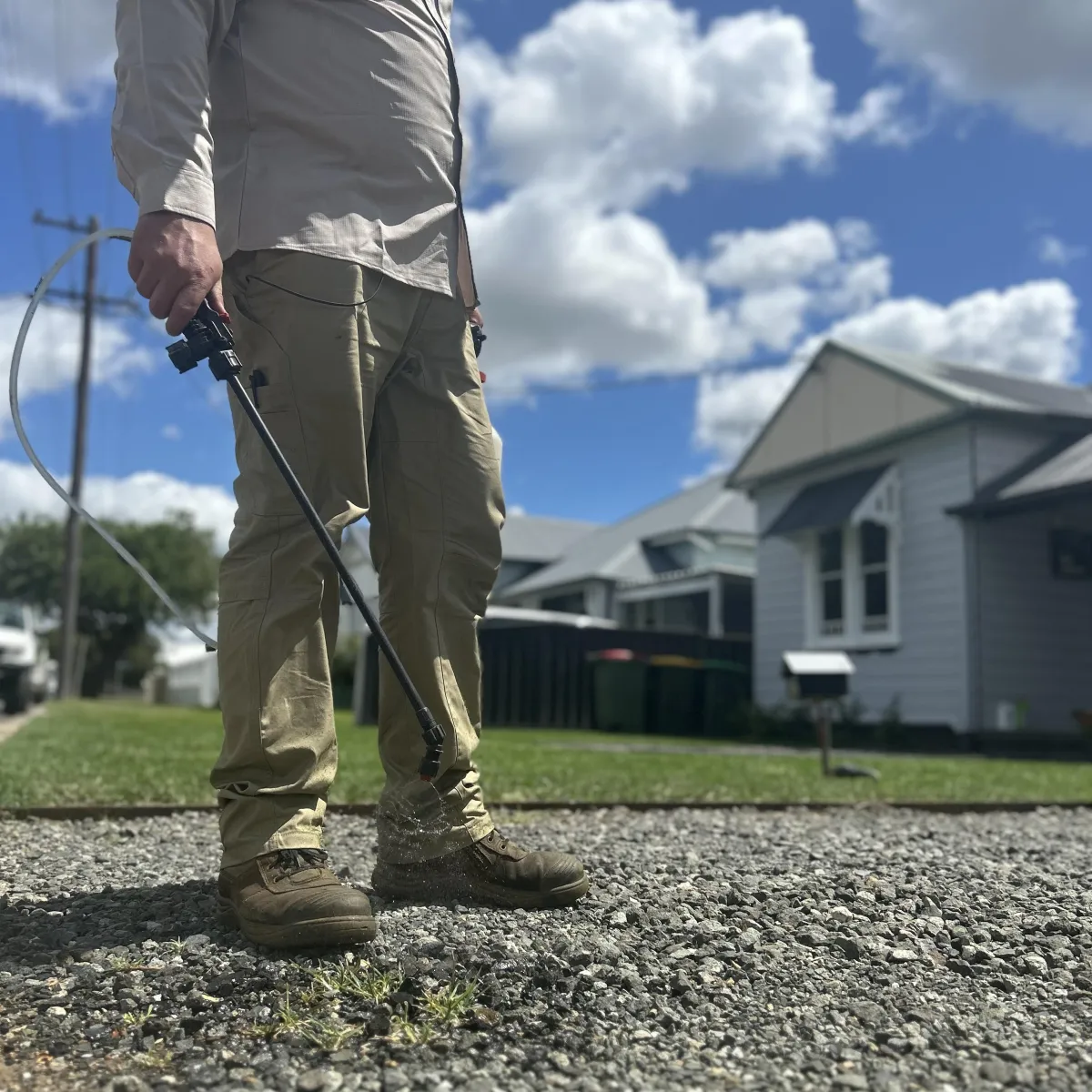 Uniformed weed control team in branded shirts, smiling and loading garden waste into a clean truck in a Cessnock suburban driveway, bright morning, 3:2 aspect