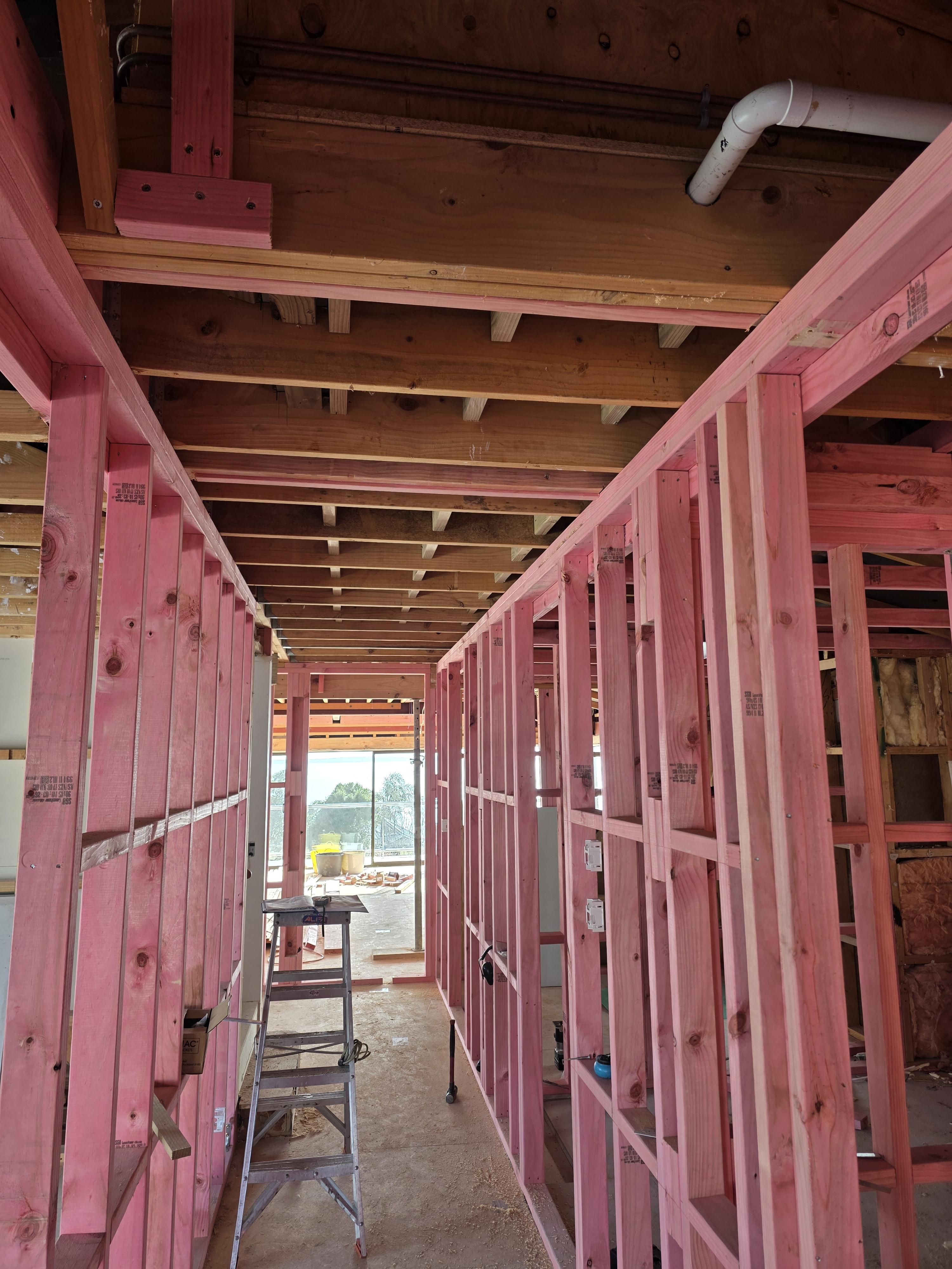 Worker measures a surface with a tape measure and pencil.