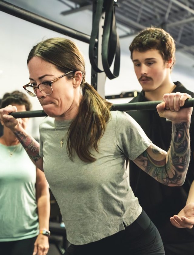 A coach spotting a barbell lift