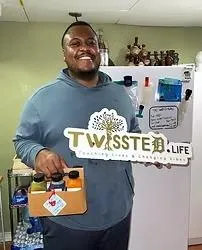 A man with a thoughtful expression holds a sign that states "Twisted Life," inviting reflection on life's complexities.