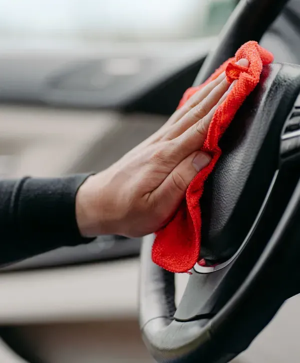 Hand cleaning car steering wheel with microfiber cloth