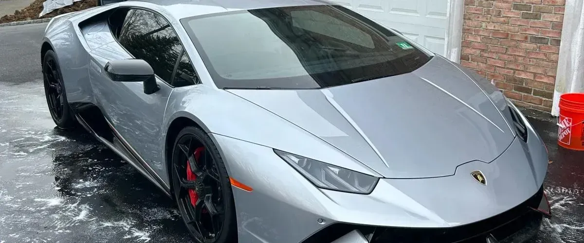Lamborghini Huracán EVO in silver, front side view with black wheels.