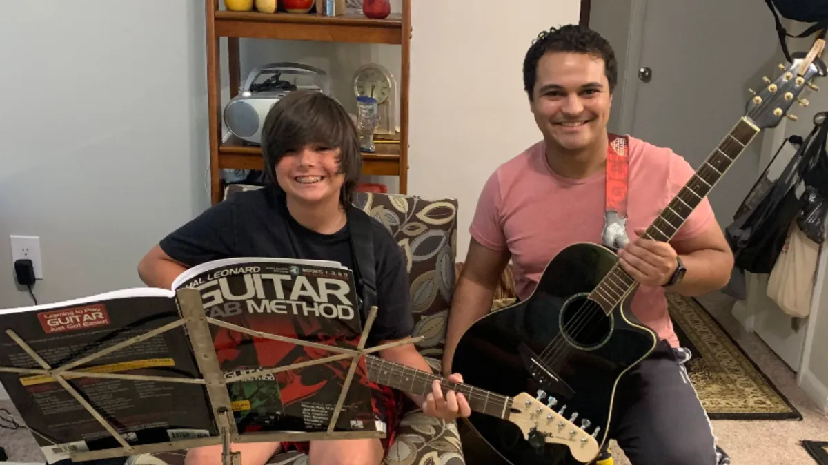 Two children playing an upright piano together, one focusing on the lower keys and the other on the higher ones. Both kids are smiling, engaged in playing, in a cozy room with warm lighting. The scene highlights the joy of collaborative music-making.