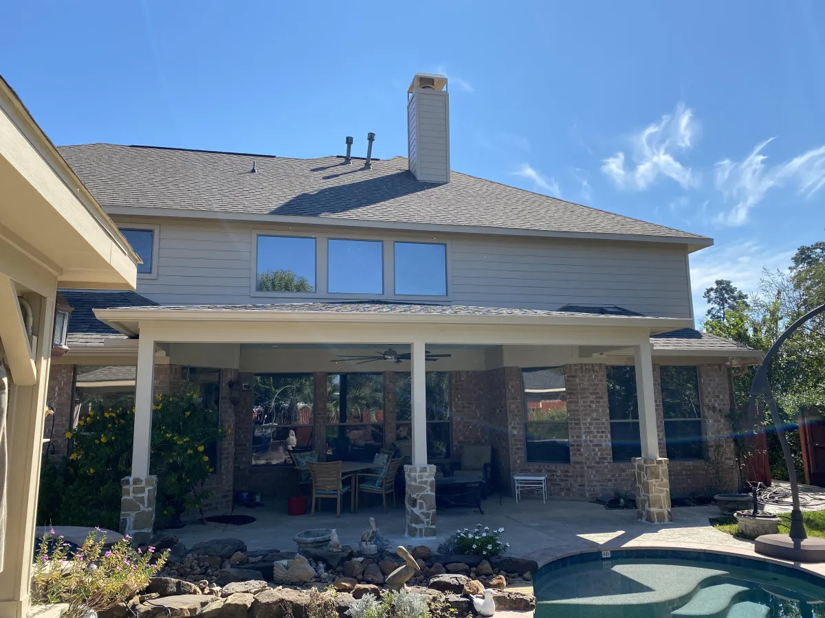 After image of a Milton covered patio and outdoor kitchen remodel featuring built-in grill, countertop bar, and stylish outdoor living space.