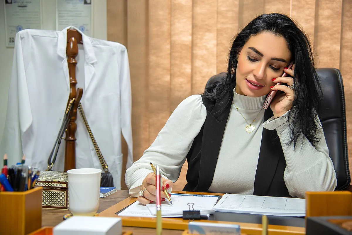 Doctor talking with a patient by phone at her desk — a realistic photo for "When You're 1,000 Miles From Home," health coverage on the road for trucking families.