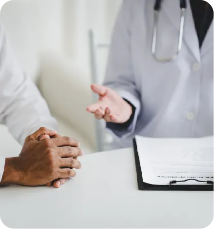 A white doctor stretching a hand to a folded black hand