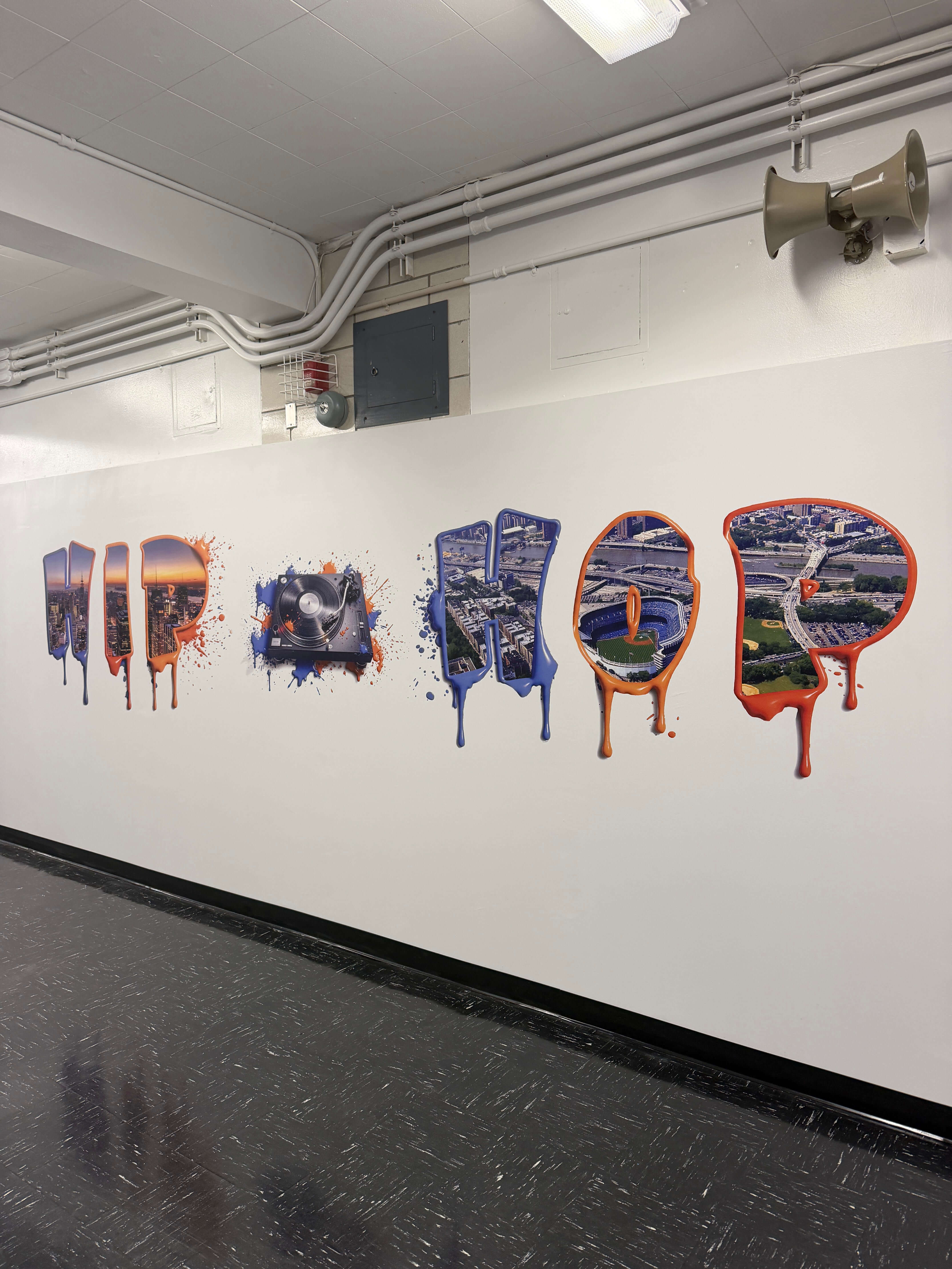 Custom Hip Hop wall mural with NYC skyline lettering printed in a school hallway by East Coast Mural Pros