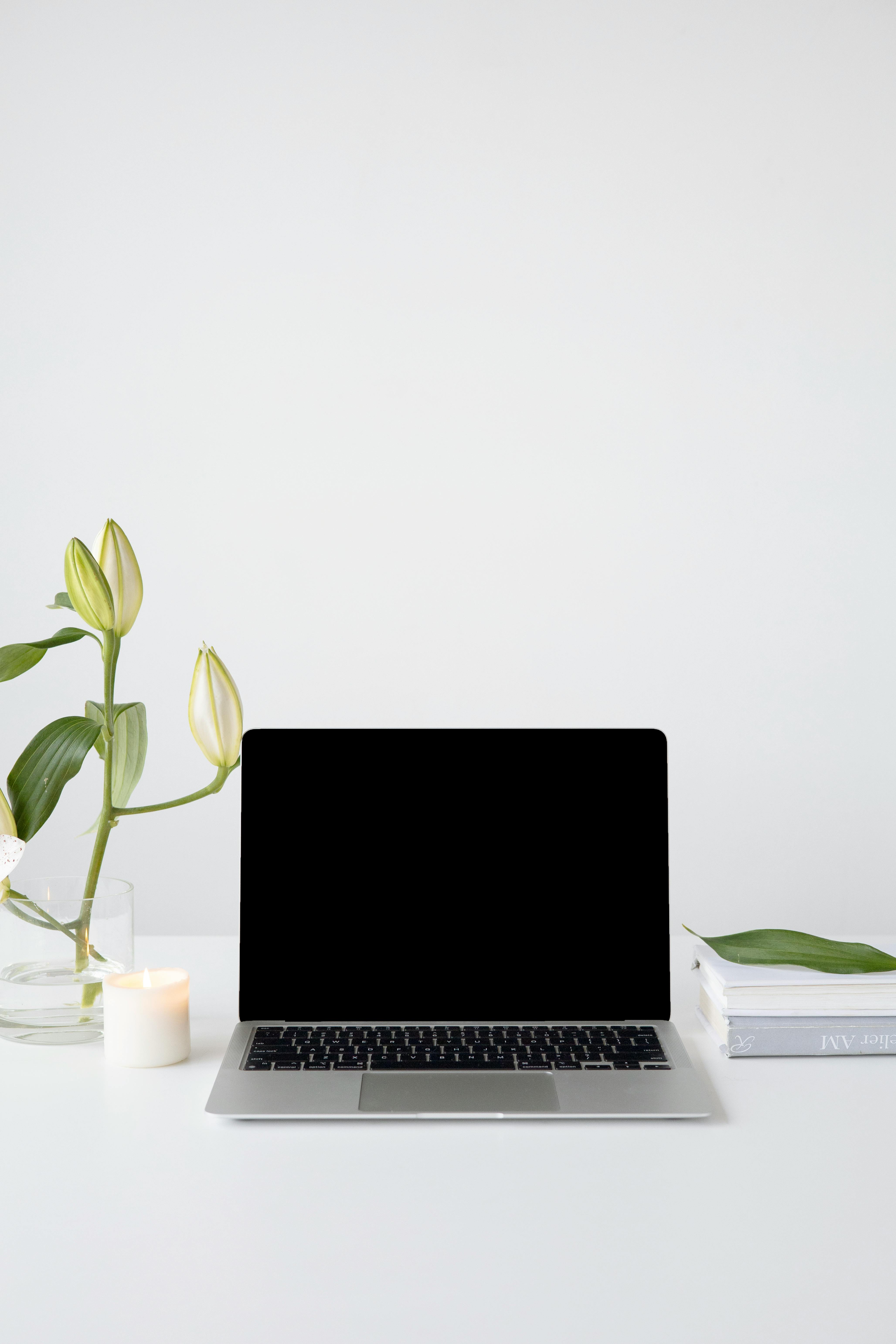 Calm workspace with laptop, candle and plant symbolising clarity, focus and supportive guidance.