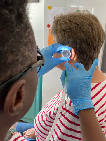 Close-up of clinical ear wax removal procedure using specialised equipment for mobile audiologist appointments