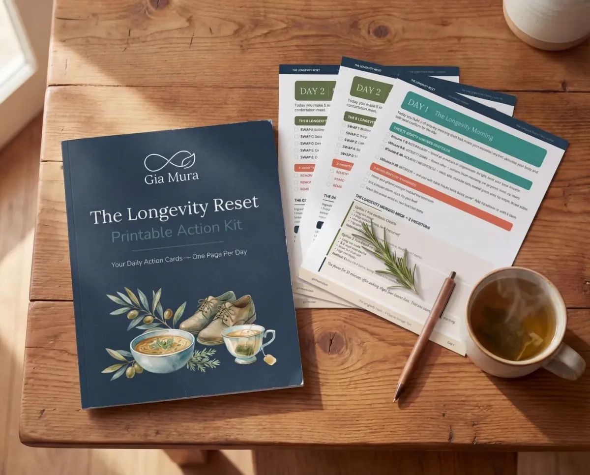 The Longevity Reset Printable Action Kit booklet with daily action cards spread on a wooden table