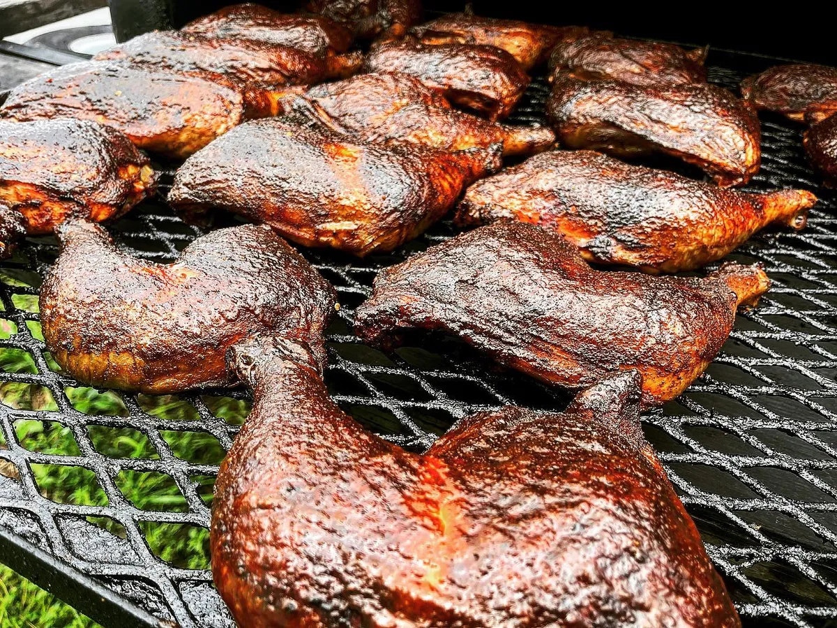 Chicken smoking on the grill grates