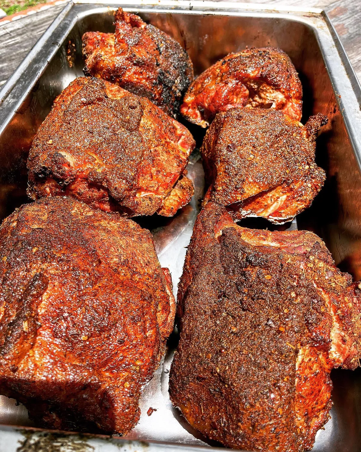 Pans of smoked meat with dark bark