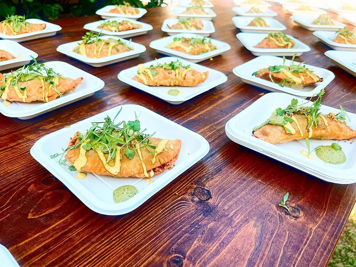 Rows of plated appetizers set out on a long wooden table