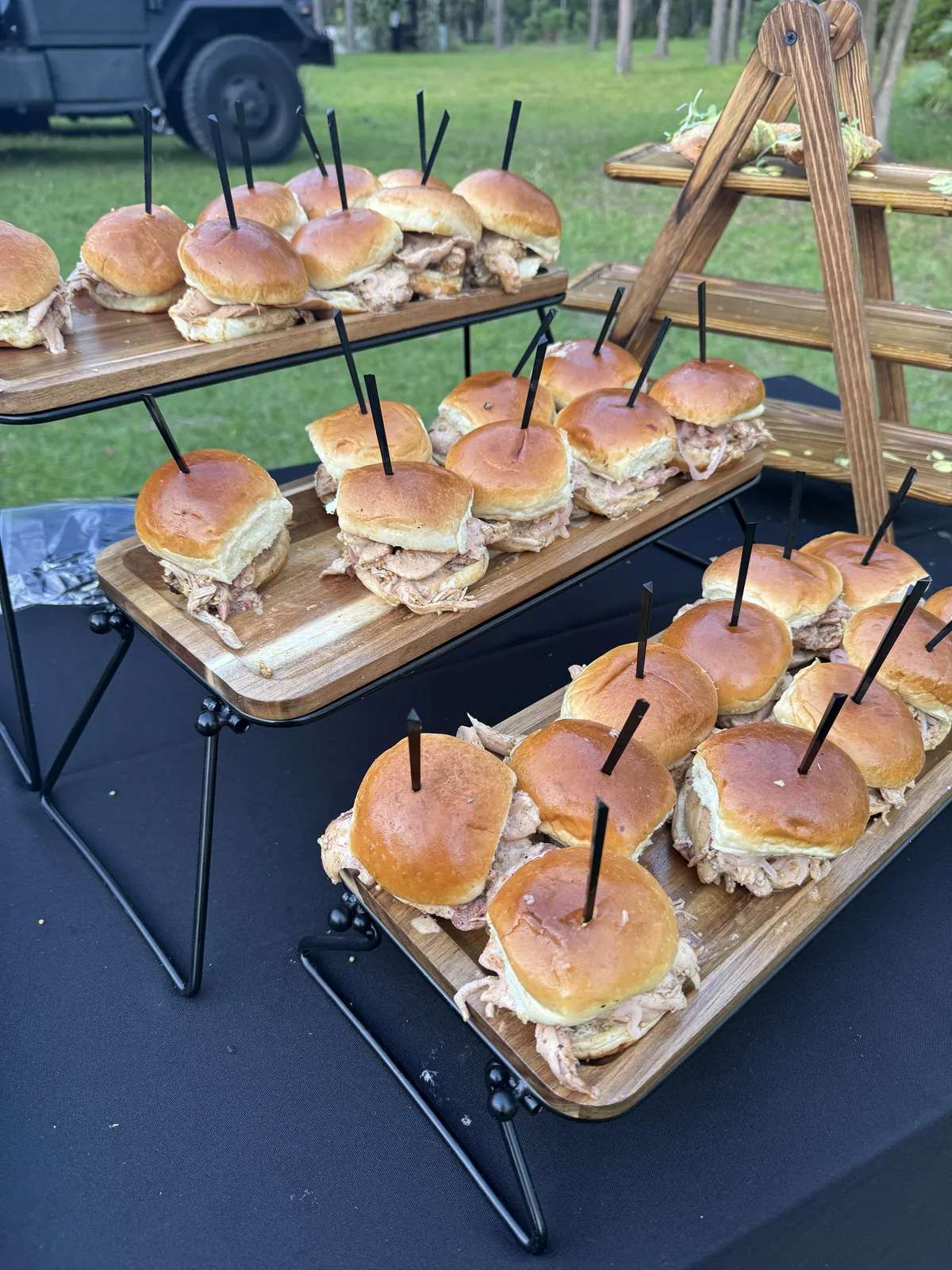 Sliders arranged on a tiered serving stand at an event