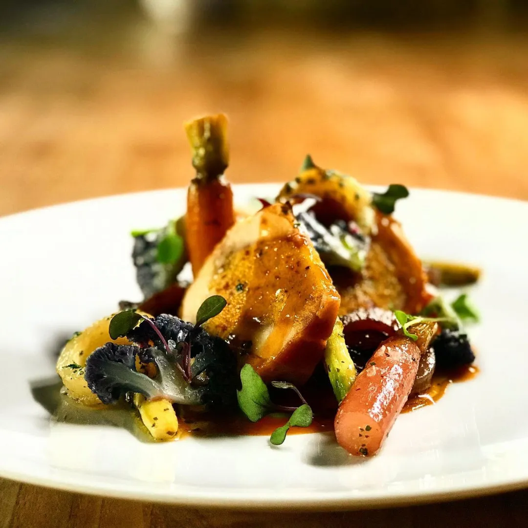 A plated entrée on a dark plate