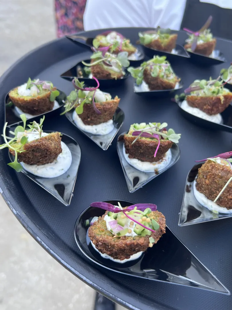 Appetizer cones lined up on a black platter