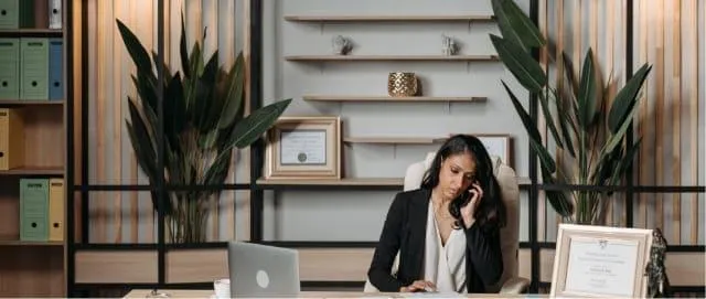 A single woman in an office making a phone call to the homebuyer.