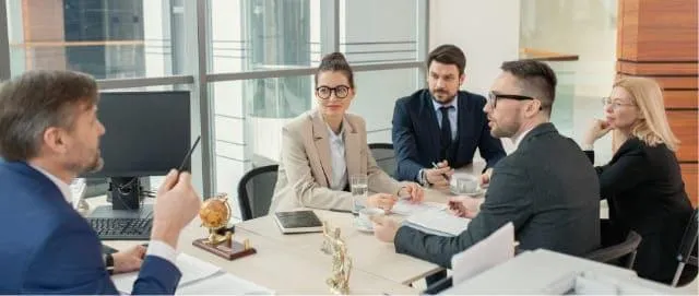 A group of professionals sitting around a table comparing and analyzing loan estimates