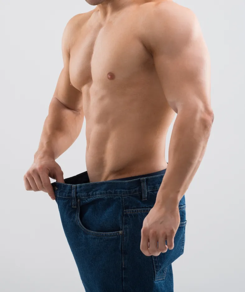 A fit man showing how much weight he lost with the extra room in his waist band..