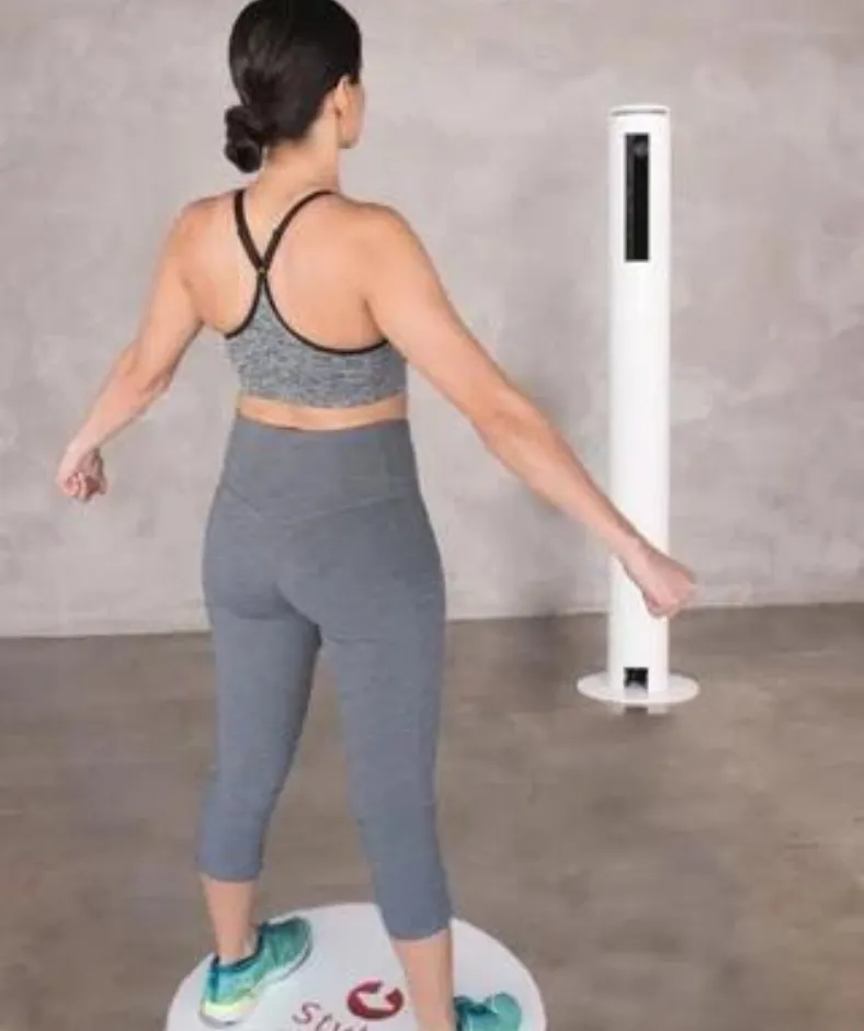 A woman standing on the pad to complete a 3-D body scan.