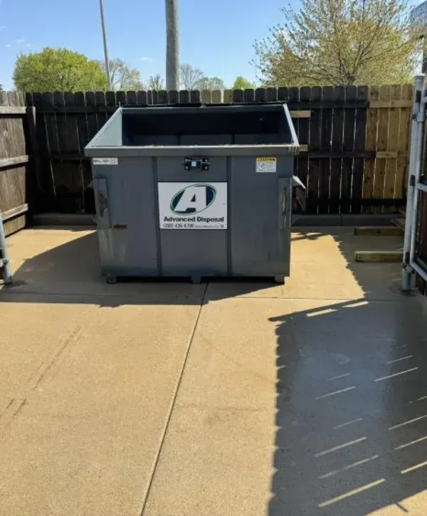 Commercial dumpster pad area with clean, freshly pressure-washed concrete