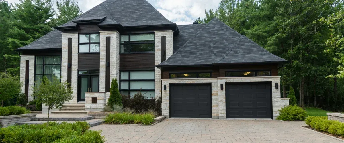 Modern home exterior with a clean driveway and landscaped front yard.