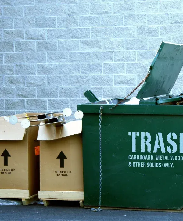 ndustrial dumpster on concrete pad behind commercial building