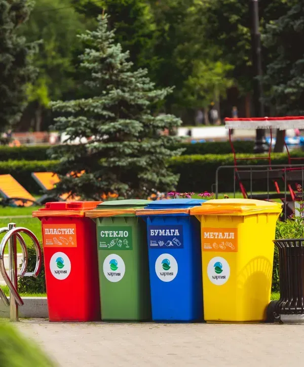Colorful recycling bins for plastic, glass, paper and metal in park setting