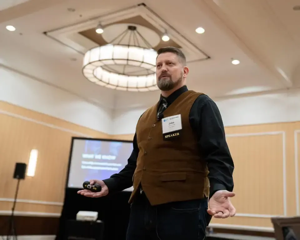 Speaker John at wellness seminar presenting hypnosis coaching and peak performance techniques