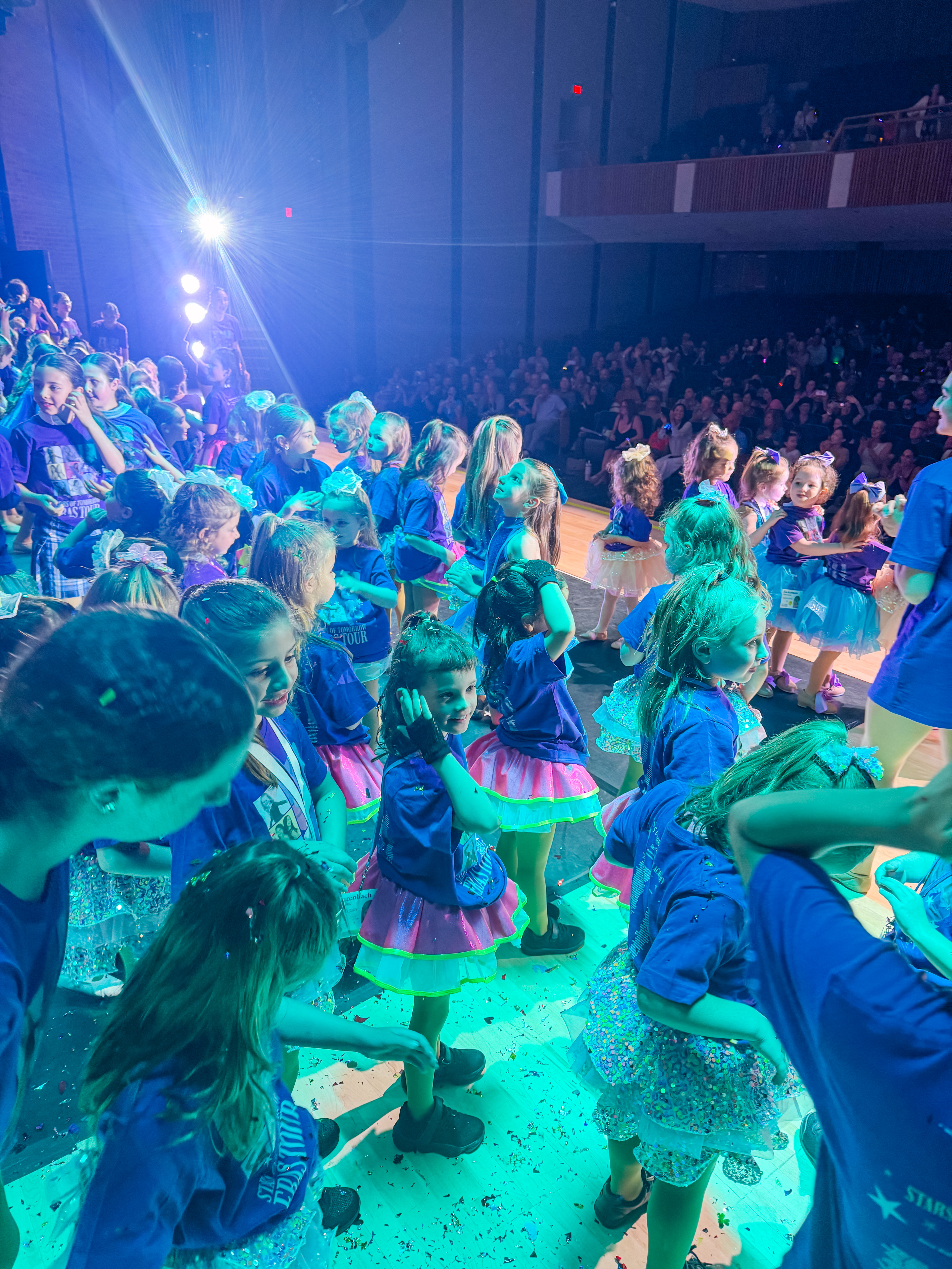 Smiling dancer in purple tutu posing before recital