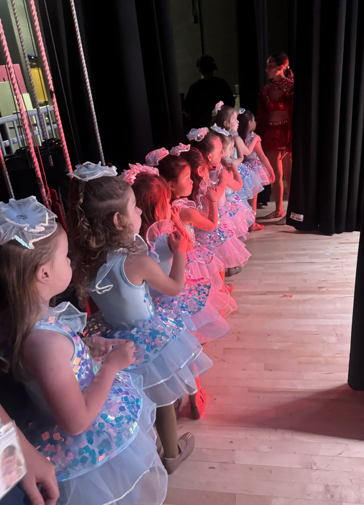 Young dancers lined up backstage waiting to perform
