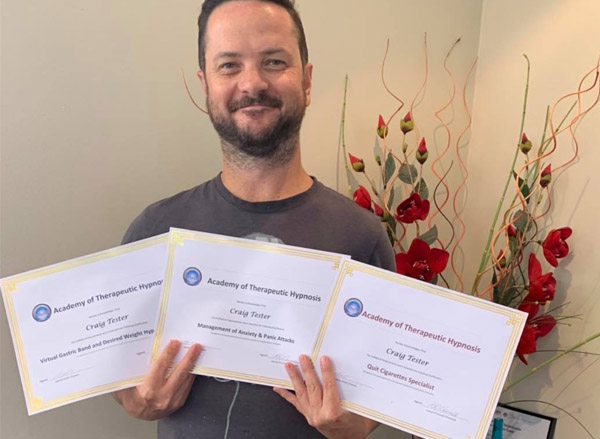 Nicholas Cornish teaching in a small in-person class, engaged with students with whiteboard notes visible.