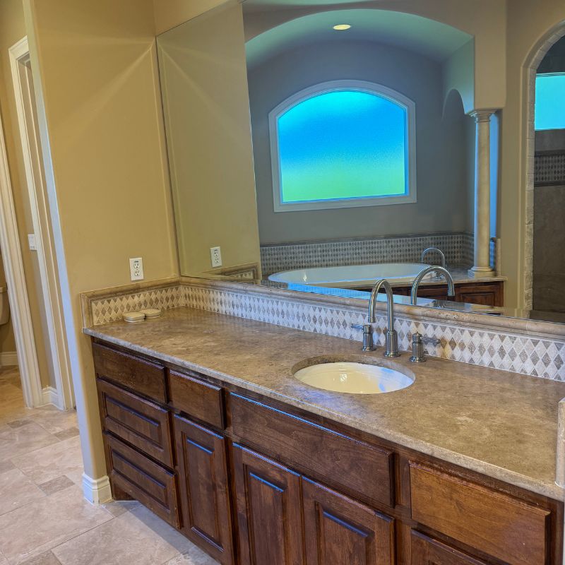 Cramped 1980s Austin bathroom with worn tile, bulky vanity, and poor lighting