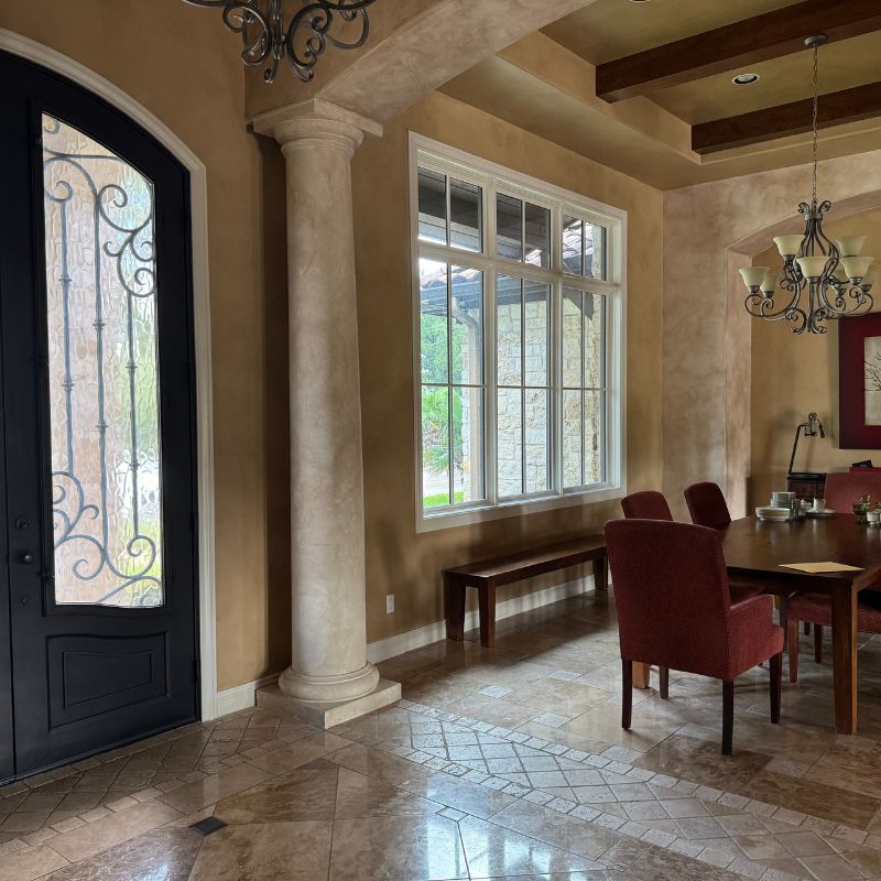 Dark closed-off living room in Austin home with bulky beams and old tile