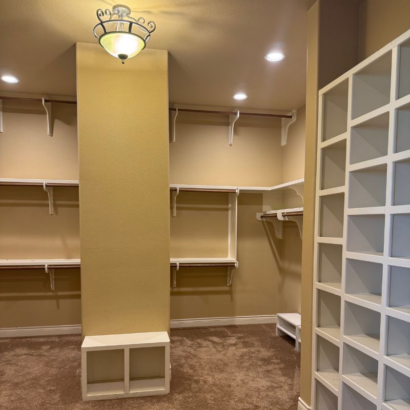 Outdated Austin master bedroom walk-in closet with little light