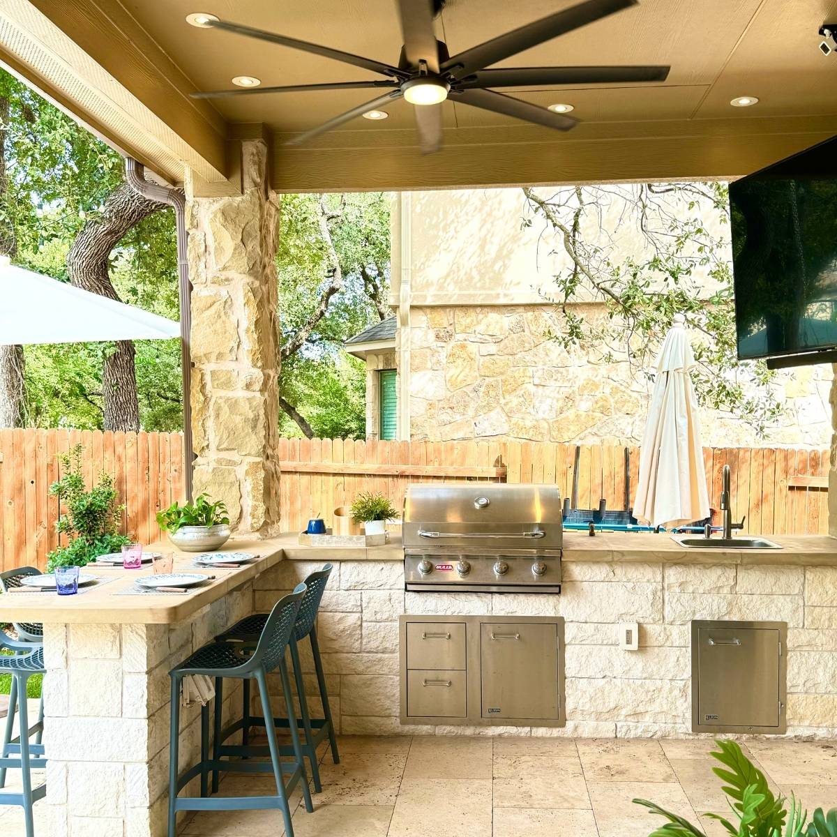 After: custom Austin outdoor kitchen with built-in grill, stone island, and pergola