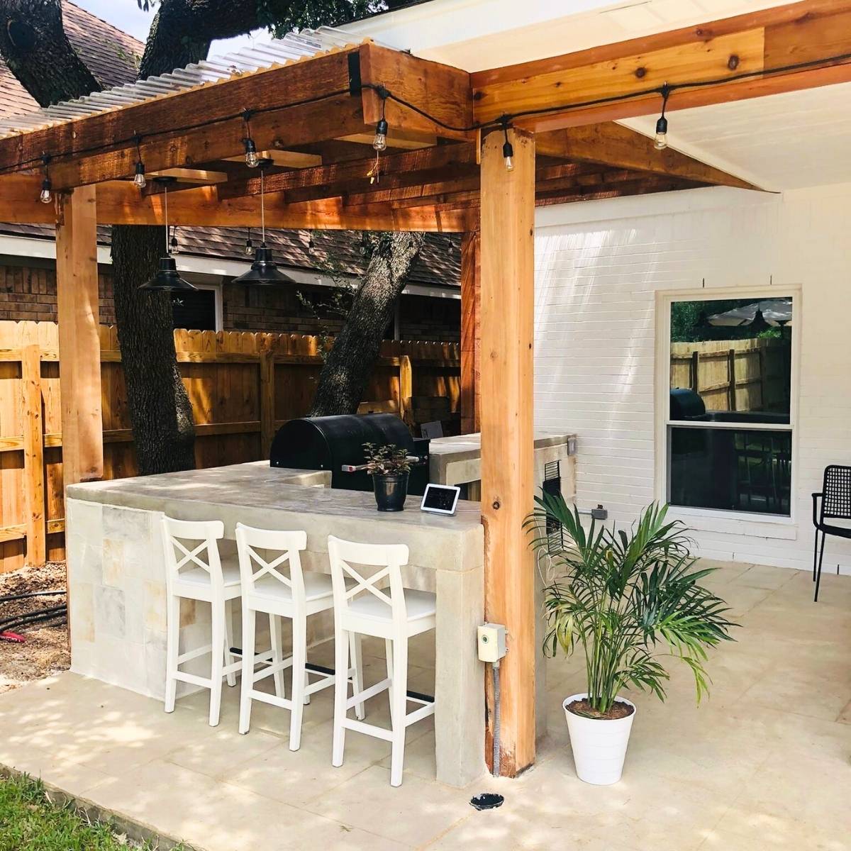 After: modern Austin outdoor kitchen remodel with concrete counters and stainless appliances